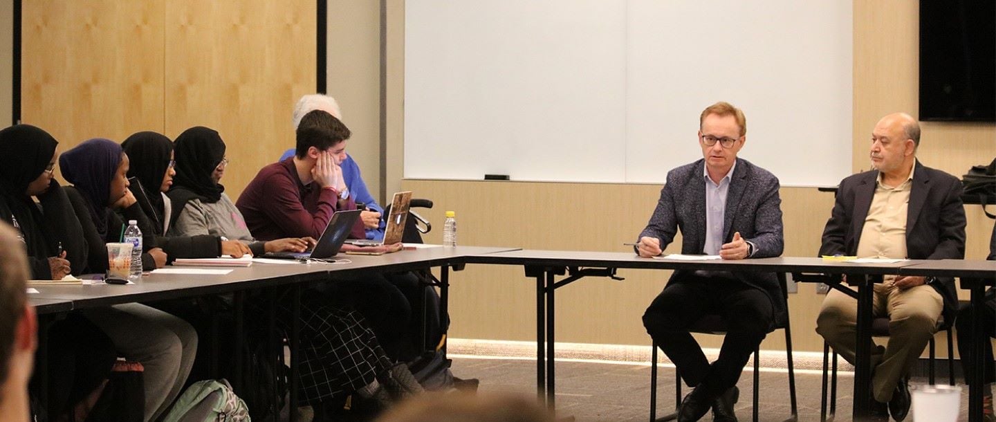 Students and professors sitting at tables during an international relations panel discussion