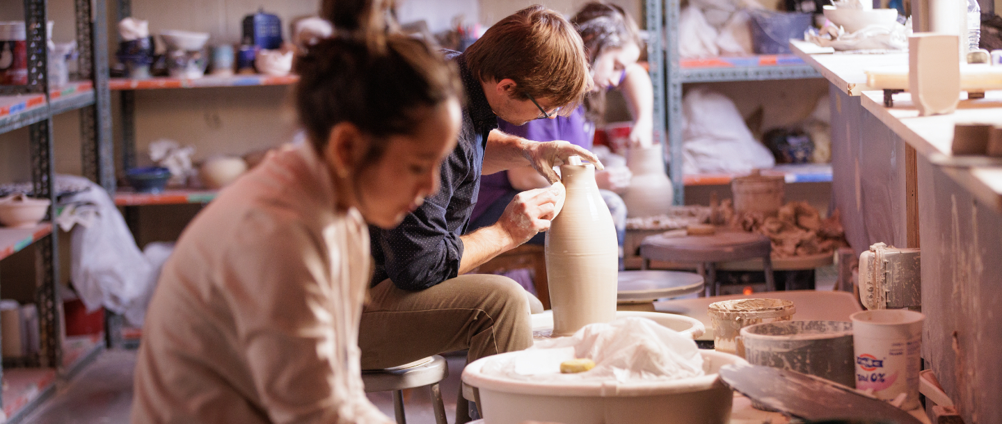 a person and person working on a vase