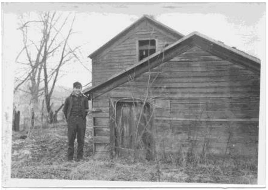 a person standing next to a small wooden house