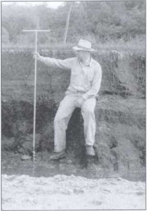 a person sitting on a rock holding a pole