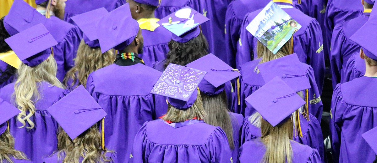 a group of people wearing purple graduation gowns